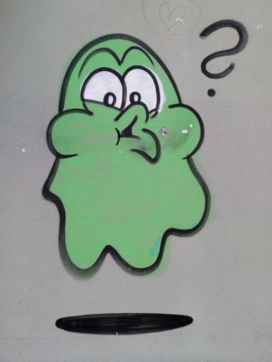 Sprayed green ghost making suprised face with a question mark next to its face, has a shadow under it to indicate that its floating. On a dark grey wall