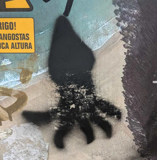 black squid stenciled with spray paint on a poster