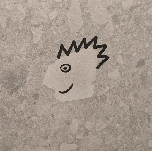 doodles on a stone wall that make one stone look like the sideview of a head